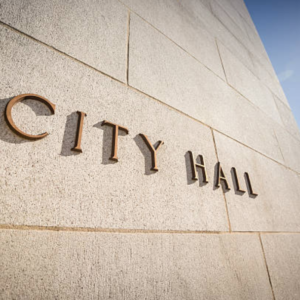 The words city hall on the side of a stone wall